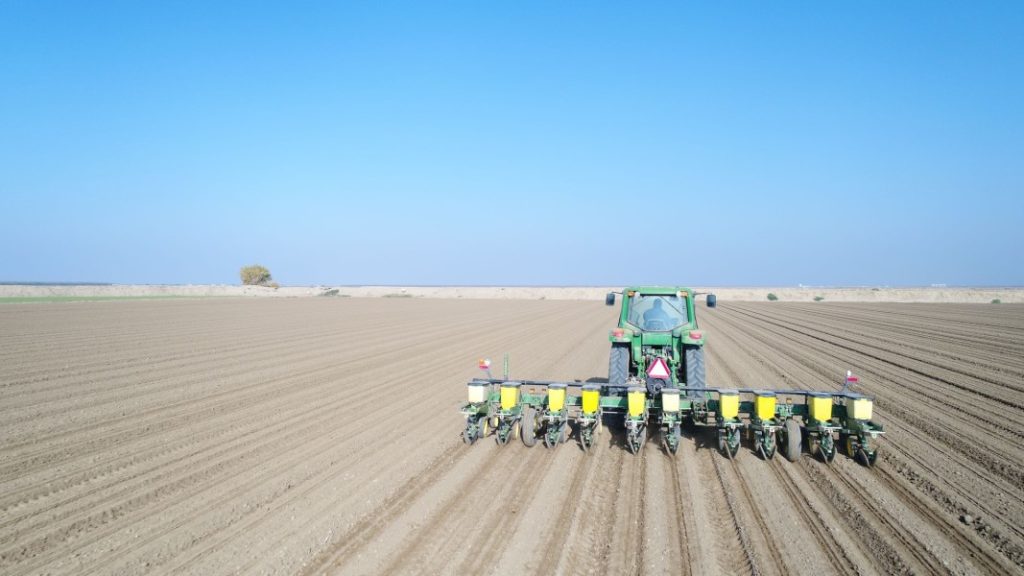 A tractor in a field farming beans in California.